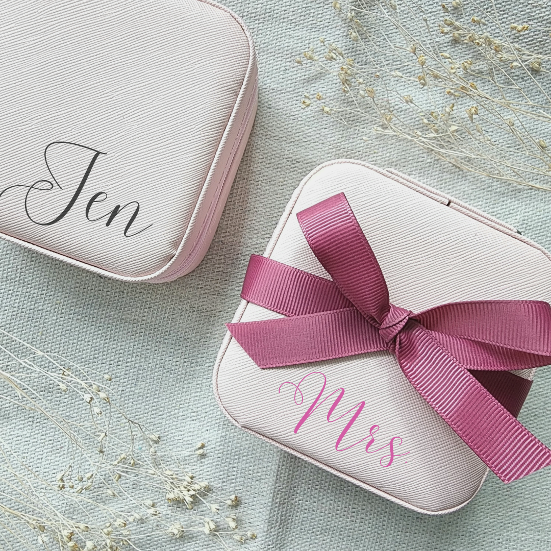Personalized jewelry box includes 3 necklace hooks, an elastic pocket, rings row and 2 removable dividers. Made of matte faux leather. Dusty Pink Color.