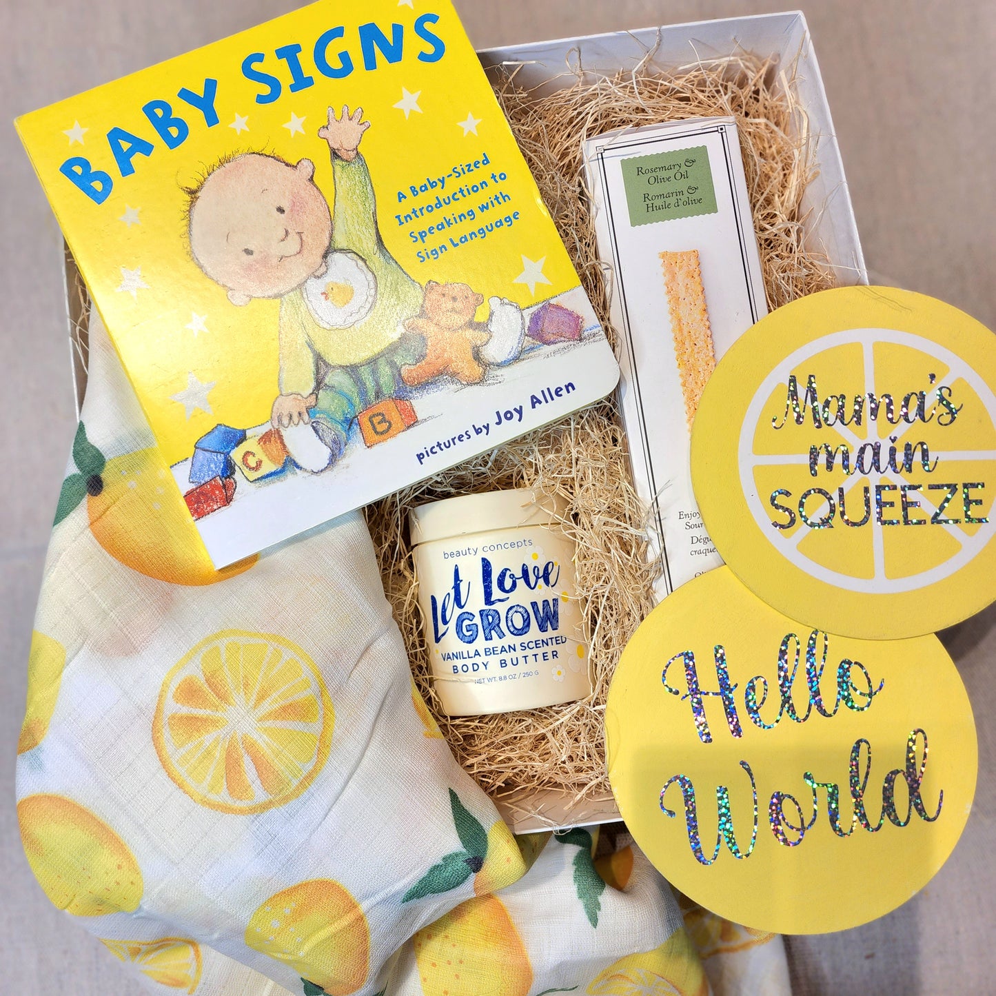 Gift box includes: - Muslin Swaddle Blanket in a Lemon Print - Baby Announcement Signs - Vanilla Bean Scented Body Butter // Beauty Concepts - Baby Signs Book // Joy Allen (Author) - Rosemary and Olive Oil Crackers // Rustic Bakery