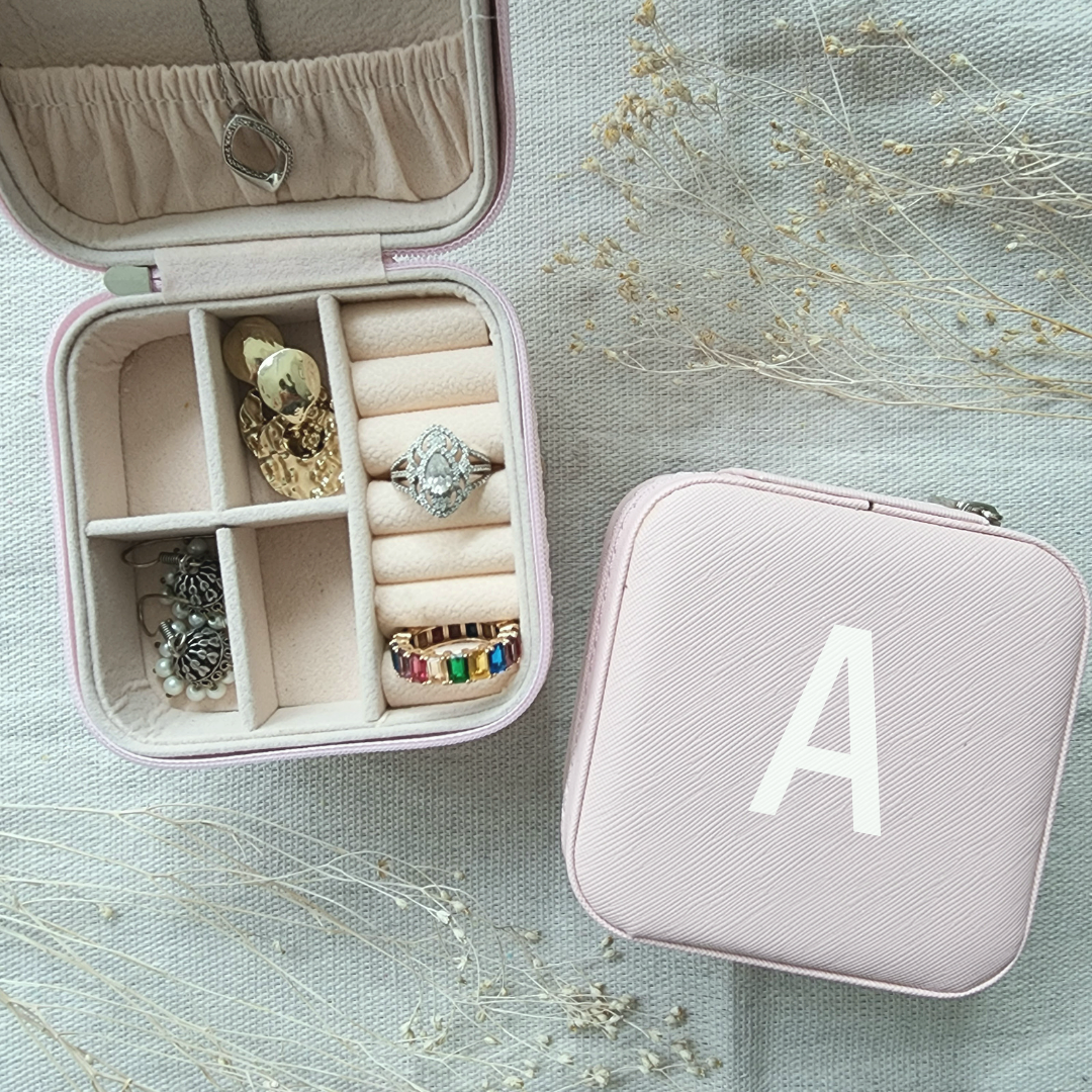 Personalized jewelry box includes 3 necklace hooks, an elastic pocket, rings row and 2 removable dividers. Made of matte faux leather. Dusty Pink Color.