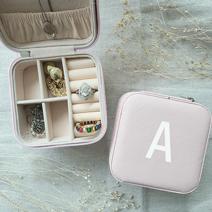 Personalized jewelry box includes 3 necklace hooks, an elastic pocket, rings row and 2 removable dividers. Made of matte faux leather. Dusty Pink Color.